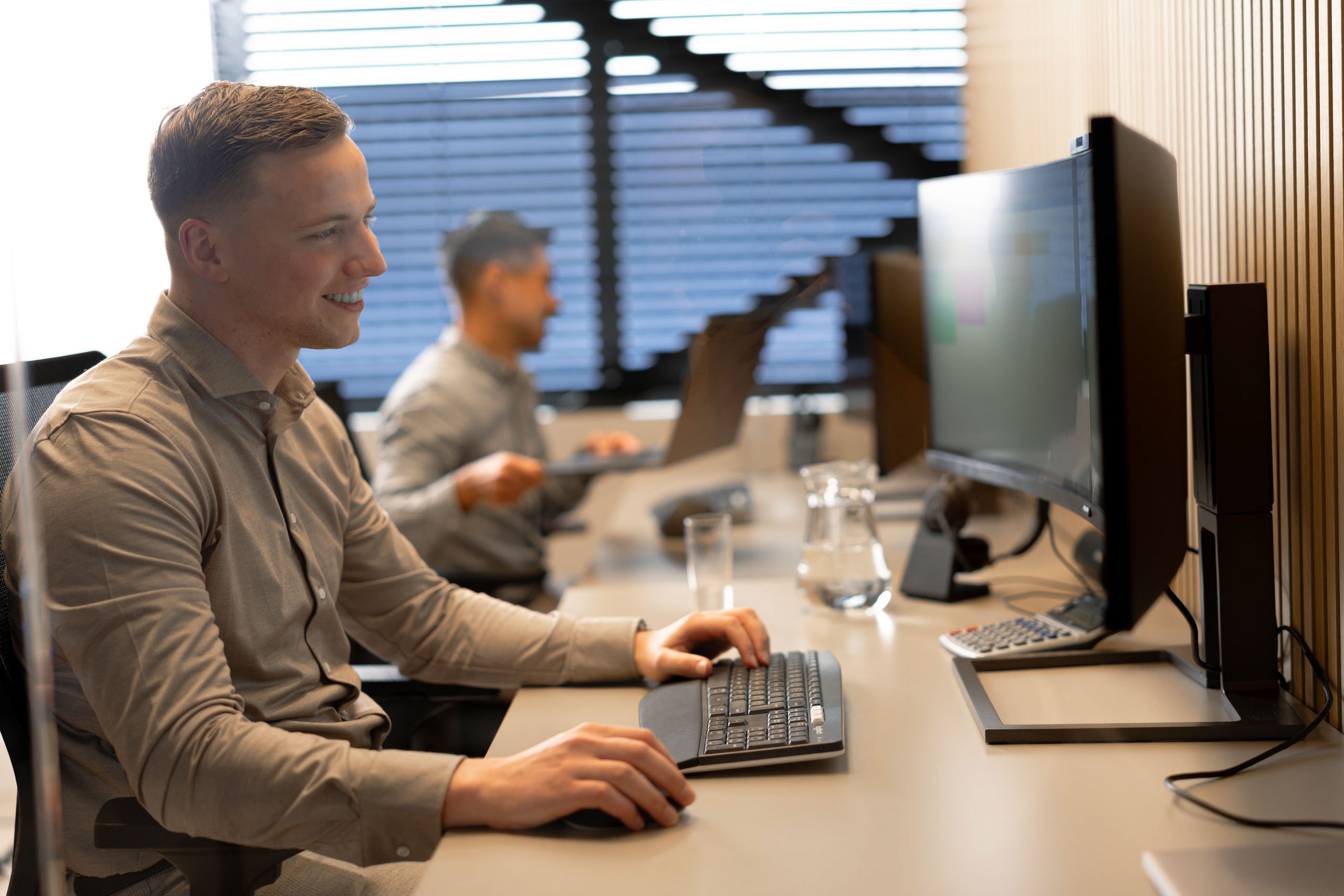 Medewerker glimlachend bureau kantoortuin accountone