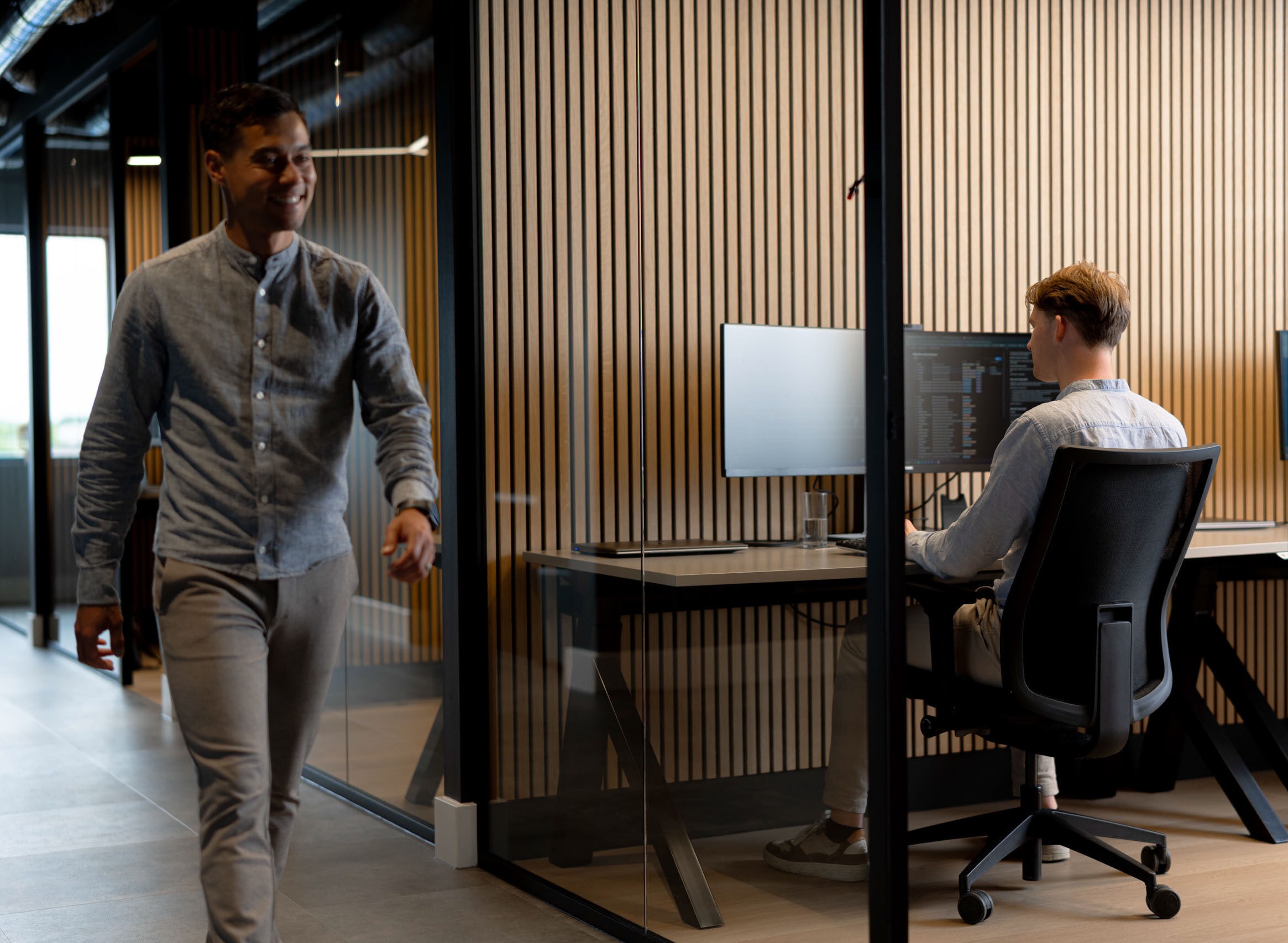 Medewerker lachend lopen kantoorgang accountone